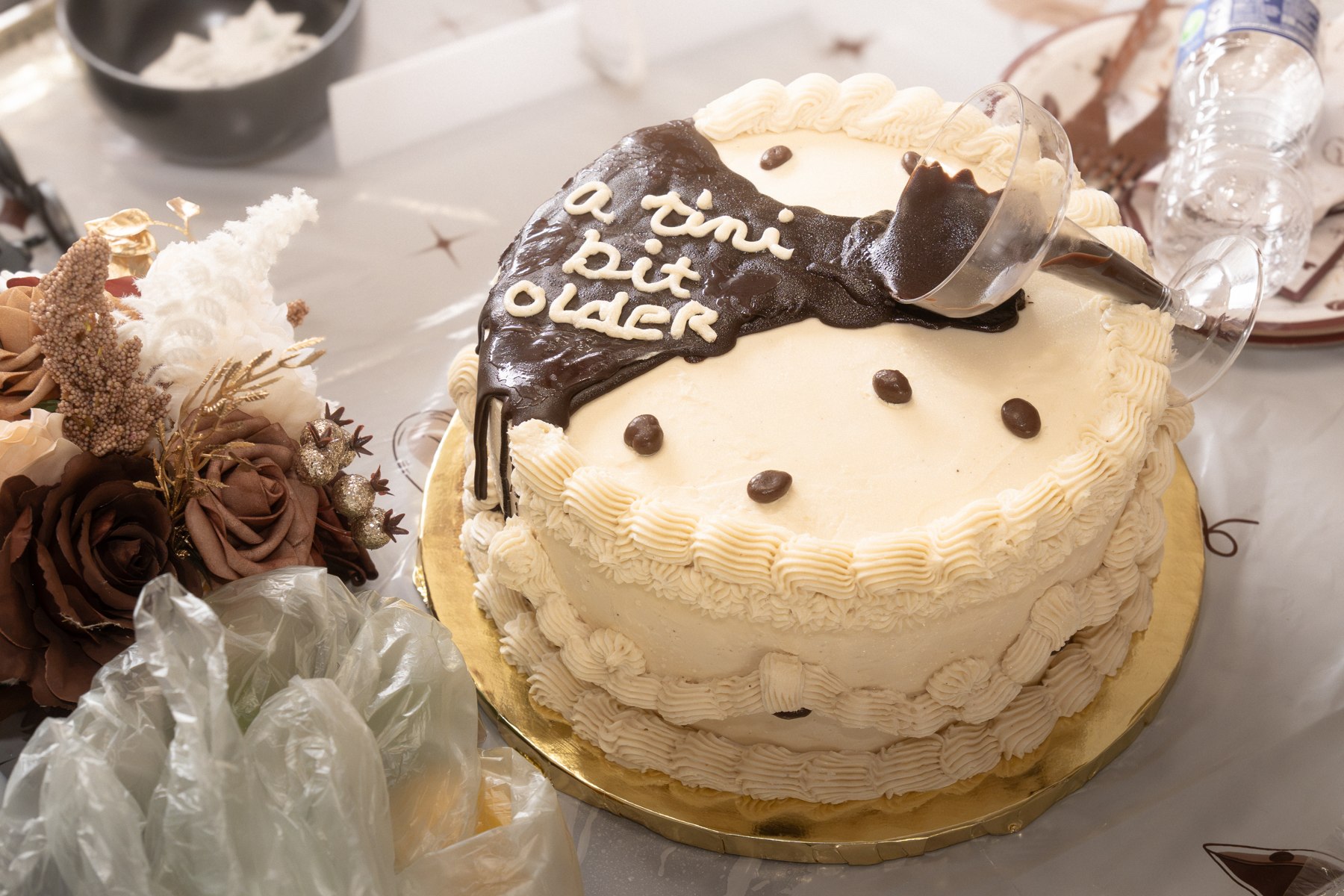 The birthday cake with a chocolate decoration reading A Tini Bit Older