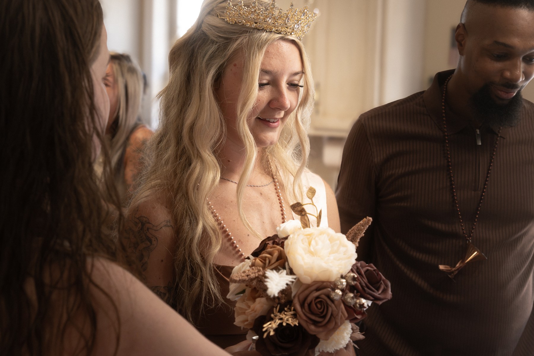 Alysa holding her birthday bouquet while guests gather around her