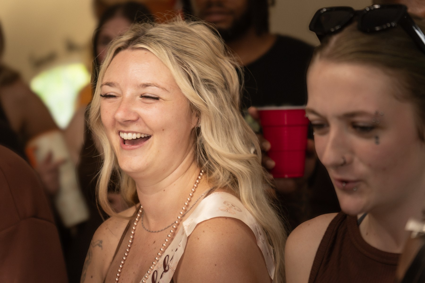 Alysa laughing with guests around a table during the birthday party