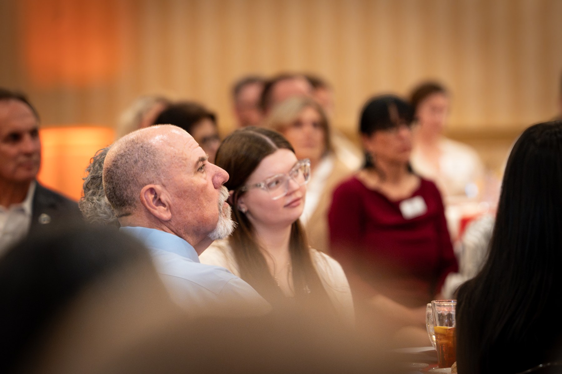 Attendees reacting to the program from their seats