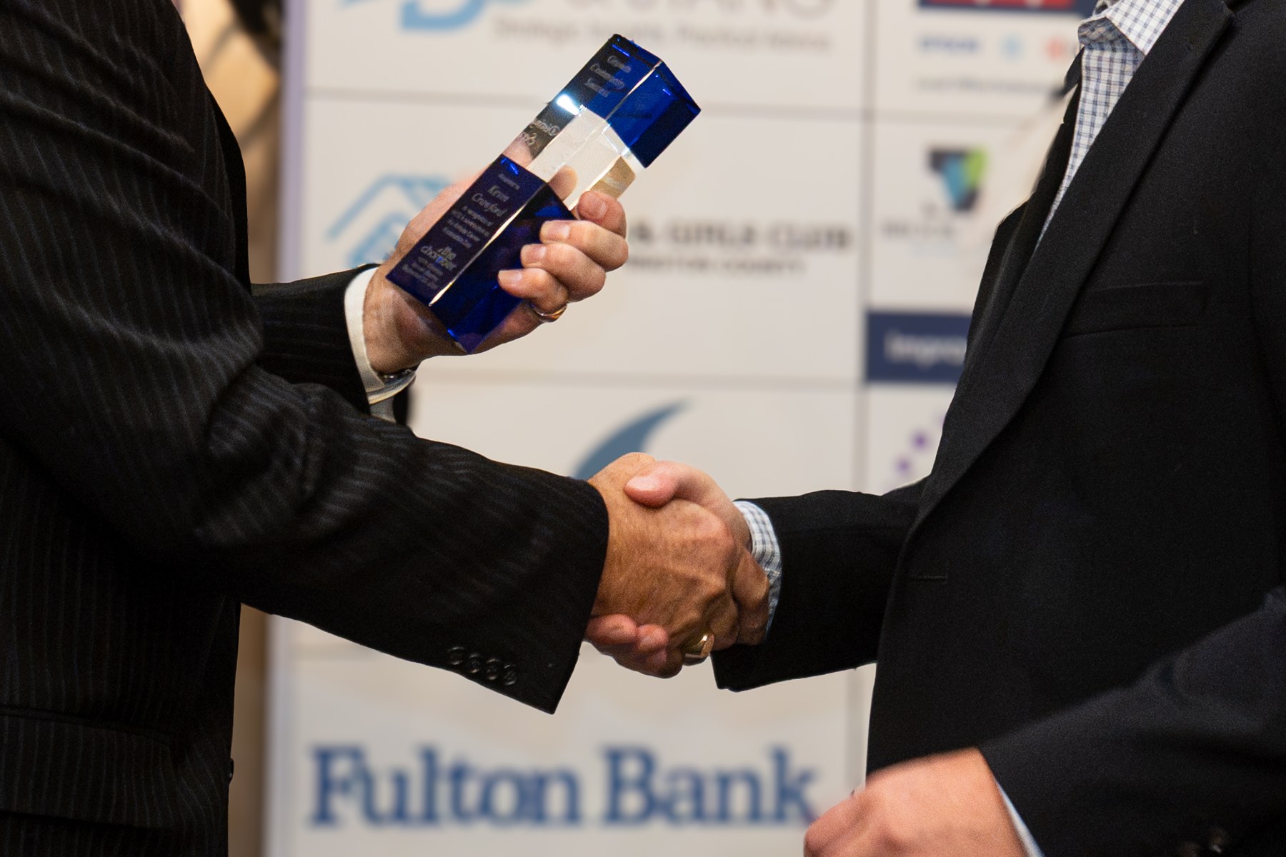 An honoree and presenter sharing a handshake during recognition
