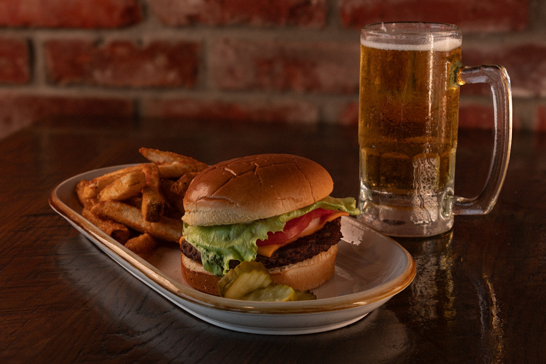Burger, fries, and beer on a wooden table
