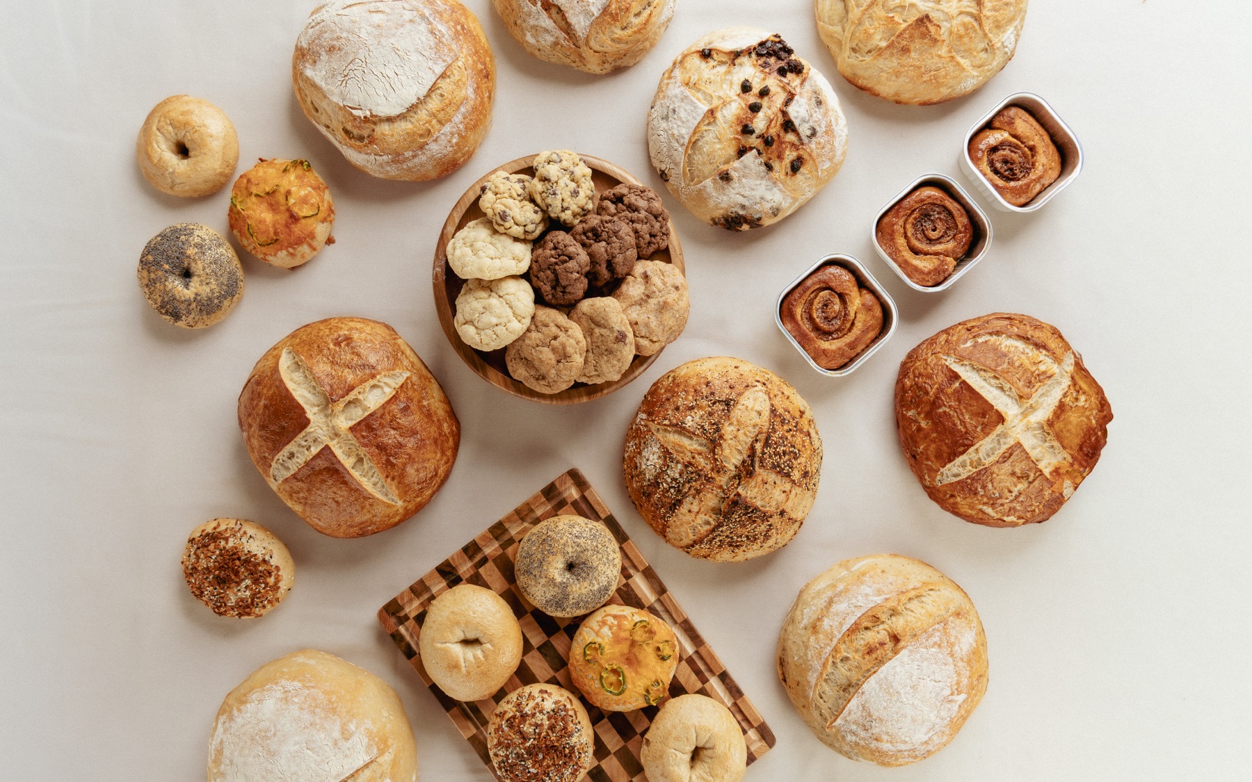 An overhead arrangement of Happy Loaf breads, bagels, cookies, and rolls.