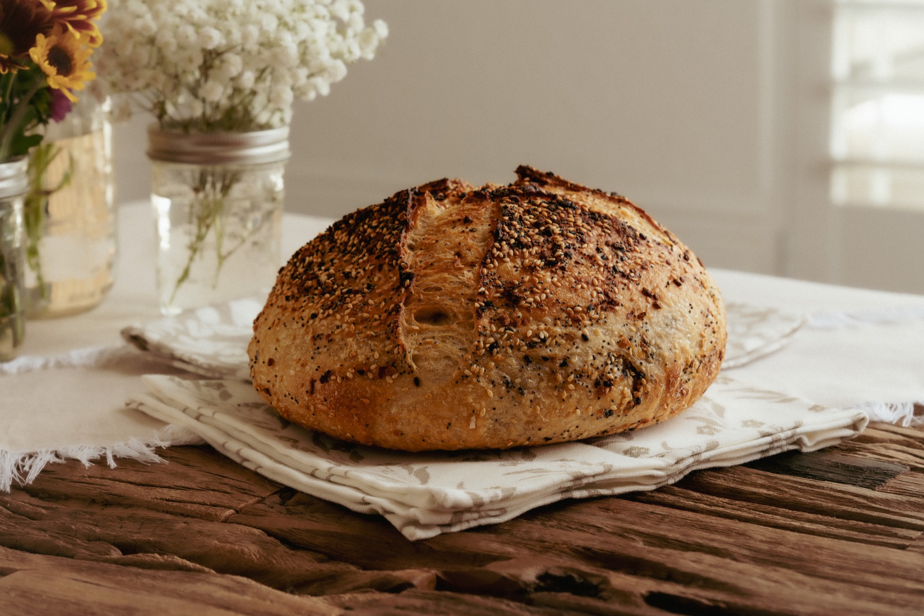 A seed-topped loaf on folded cloth, photographed from the same angle.