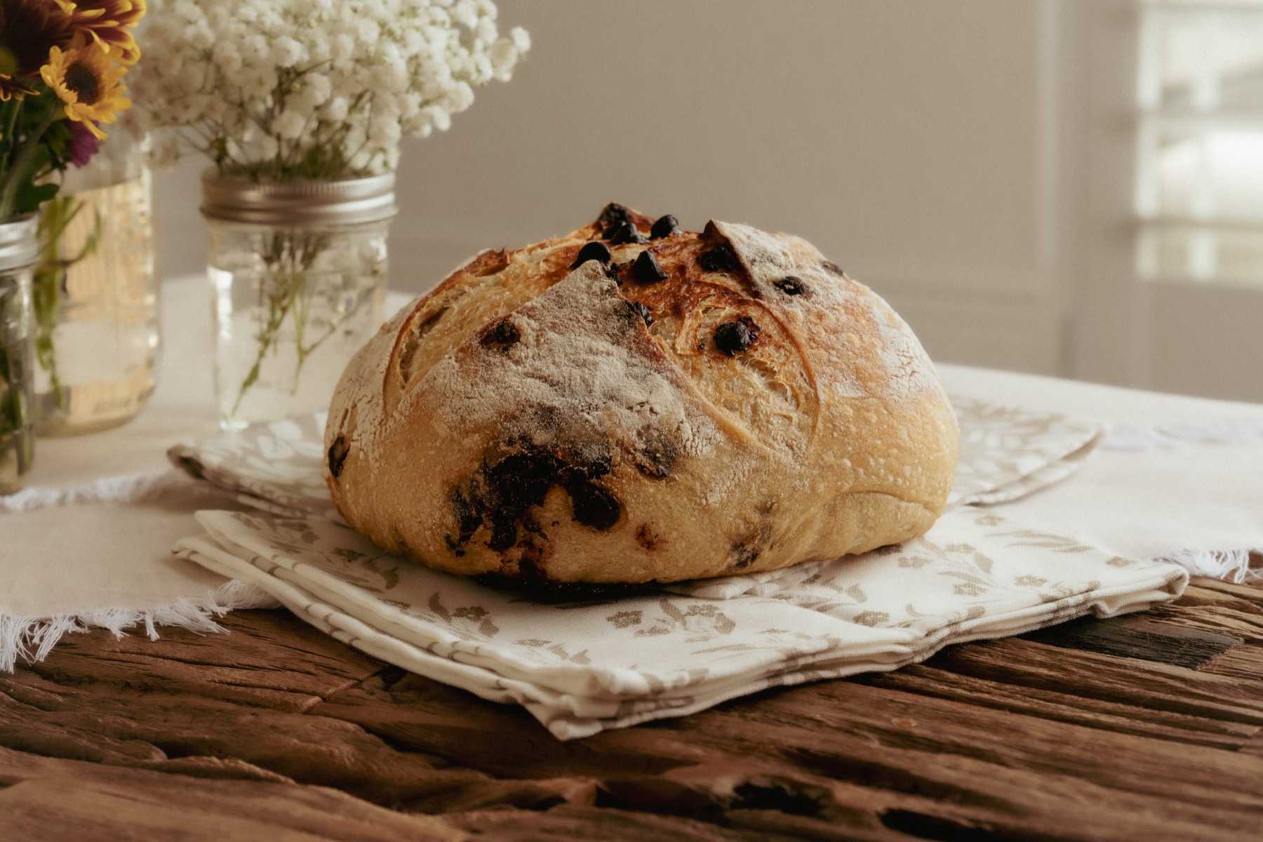 A loaf with dark inclusions on folded cloth, photographed from the same angle.