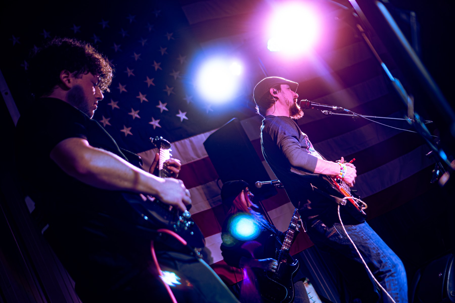 Musicians performing under purple stage lights