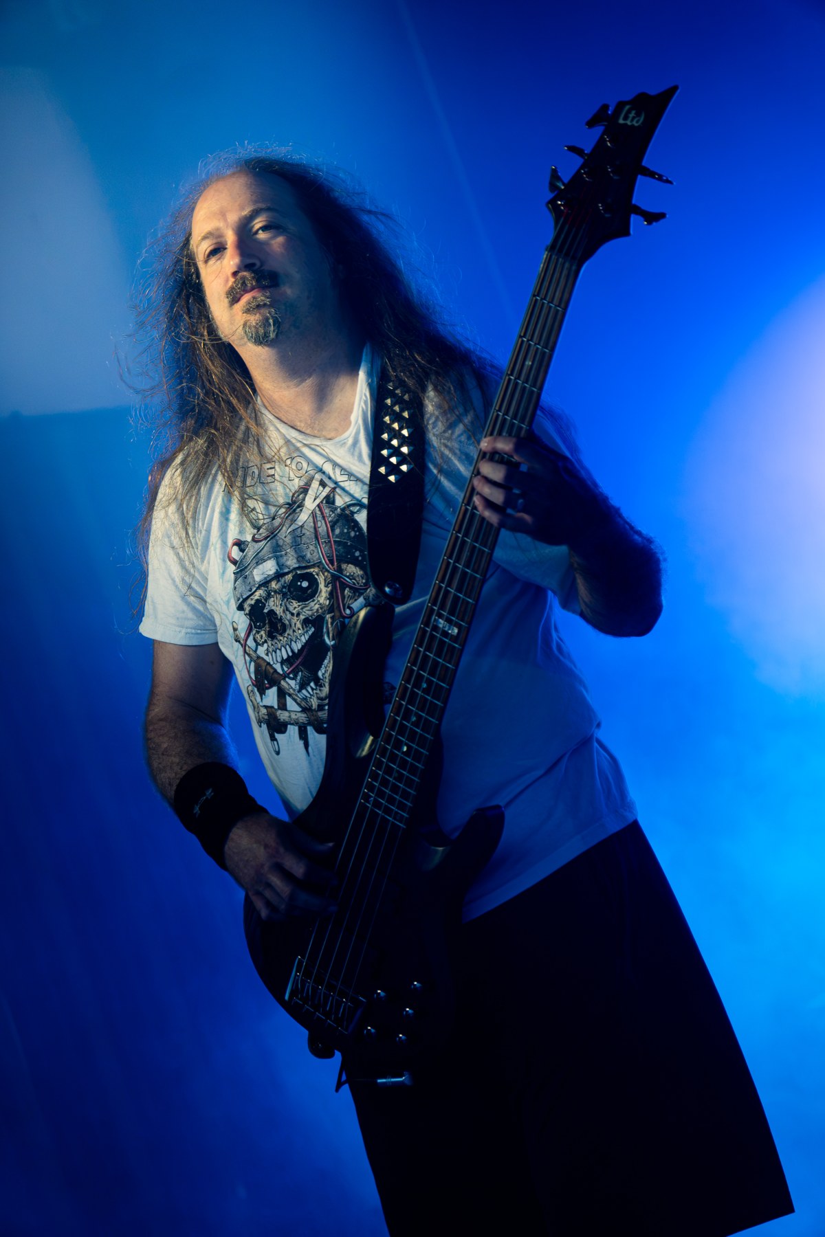 A guitarist performing under blue light