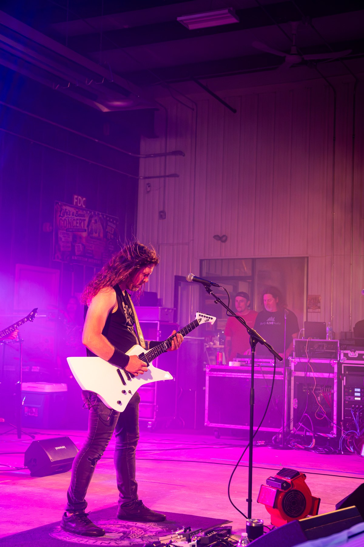 A performer surrounded by magenta stage lighting