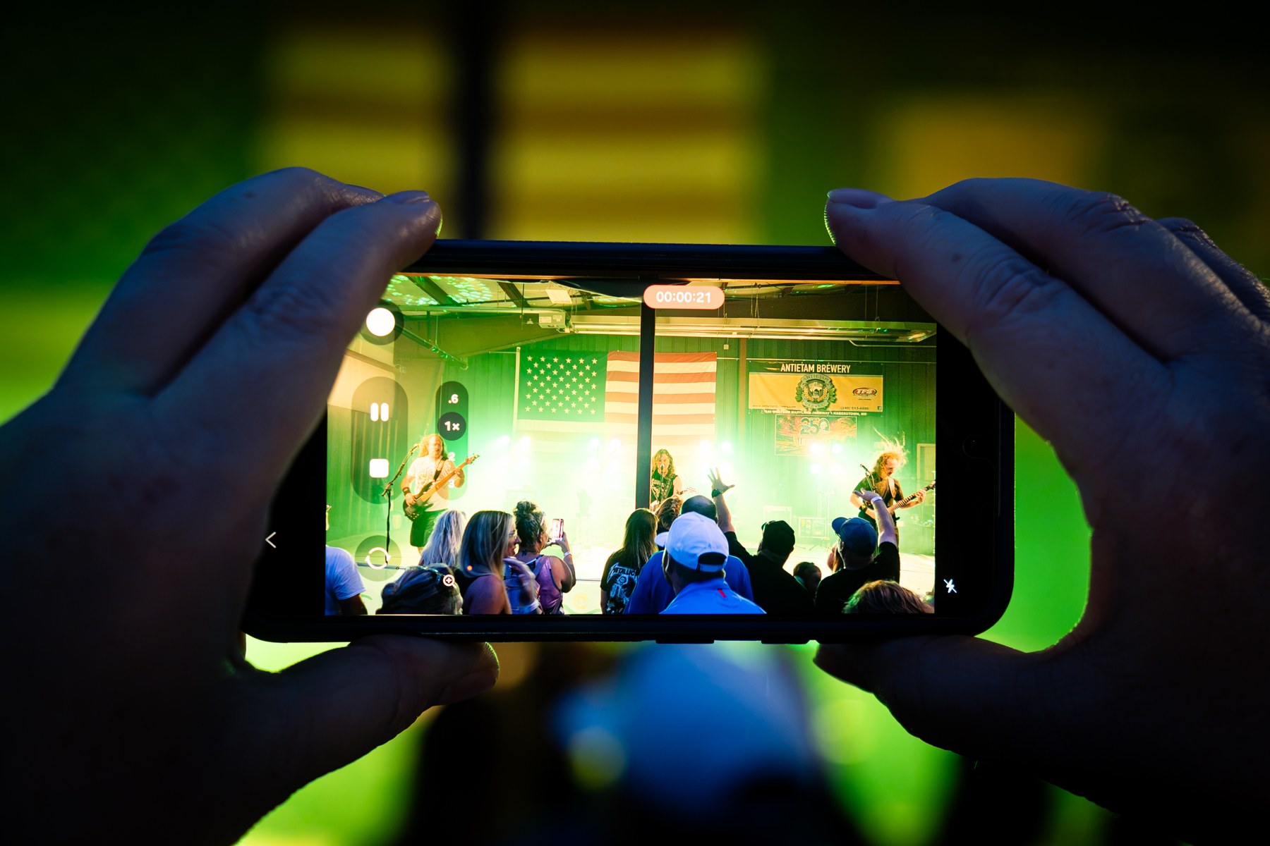 An attendee recording a performer on their phone