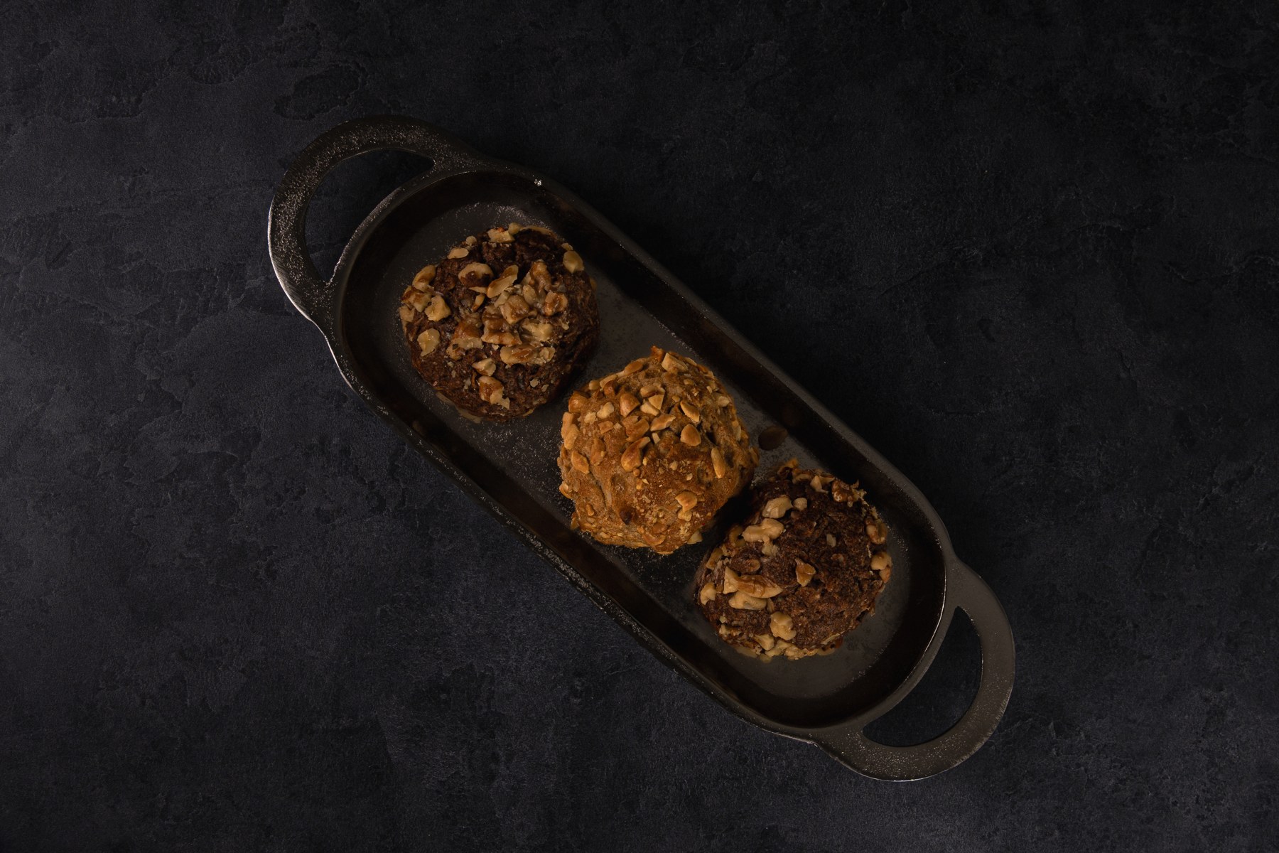 An assortment of cookies photographed on a tray against a dark backdrop