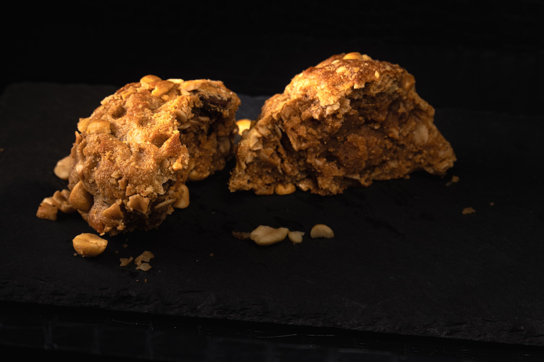 A broken cookie photographed against a dark background
